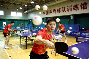 中国国家乒乓球队队员在训练馆内进行多球练习的场景